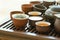 Tea set ceramic cups pot utensils on wooden bamboo dripping tray. Chinese Japanese ceremony. Freshly brewed beverage. Lifestyle