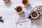 Tea set teapot and brewed tea in cups with dried leaves on white wooden table, green black herbal homemade hot beverage in