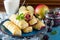 Tea and sliced home apple minischtrudel with fresh apples, cherries, blackberries and sugar powder on an antique wooden background