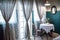 Tea table set with plant pots beside large windows and large gray curtains with sunlight filter