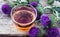 Tea with a thistle and flowers of a thistle medicinal plant on a wooden background. Pink thistle thistle flower. Herbal tea