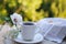 Tea in a white cup, macaroni cakes in a wicker plate with a napkin, white flowers, concept of summer tea on the terrace, herbal