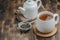 Tea. White cup of tea, dry teas and teapot ona wooden background
