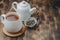 Tea. White cup of tea, dry teas and teapot ona wooden table. Copyspace