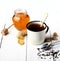 Tea in white metal mug, ginger, sugar and honey on a white background