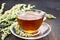 Tea with wormwood in glass cup on table