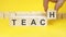 teach symbol. businessman turns wooden cubes the words renew. beautiful yellow background, copy space. business, concept