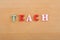 TEACH word on wooden background composed from colorful abc alphabet block wooden letters, copy space for ad text