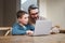 Teach your children the meaning of dedication. a father and son team using a laptop to complete school work.