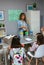 Teacher asking to girl with raising hand in ecology classroom