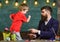 Teacher with beard, father and little son having fun in classroom, chalkboard on background. Fatherhood concept. Child