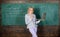 Teacher blonde woman with modern laptop surfing internet chalkboard background. School innovation. Distance education