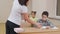 Teacher checking copybook of pupil in classroom.