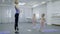 Teacher of children`s dance school shows girls exercises in studio.