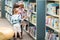 Teacher With Children Selecting Book In Library