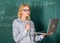 Teacher elegant lady with modern laptop surfing internet chalkboard background. Distance education concept. Woman