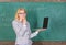 Teacher elegant lady with modern laptop surfing internet chalkboard background. Woman teacher wear eyeglasses holds