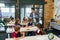 Teacher of elementary school puts notebooks on desks pupils for learning. Group of schoolchildren primary school sitting