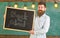 Teacher in eyeglasses holds blackboard with title back to school. Education and studying concept. Man with beard and