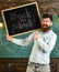 Teacher in eyeglasses holds blackboard with title back to school. High school concept. Man with beard and mustache on