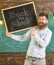 Teacher in eyeglasses holds blackboard with title back to school. High school concept. Man with beard and mustache on