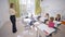 Teacher female interacts with little cute children schoolchild at desks during education lesson in classroom at School