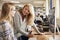 Teacher With Female Student Working On Computer In College Library