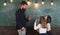 Teacher and girls pupils in classroom near chalkboard. Man with beard in formal suit teaches schoolgirls physics