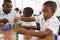 Teacher helping elementary school boy counting with blocks