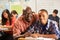 Teacher Helping Male Pupil Studying At Desk In Classroom