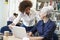 Teacher Helping Mature Student With Studies In Library