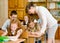 Teacher helps the schoolkids with schoolwork in classroom
