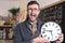 Teacher holding large clock in classroom