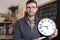 Teacher holding large clock in classroom