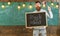 Teacher holds blackboard with written phrase back to school and flag of USA. American school concept. Man with beard on