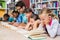 Teacher and kids reading book in library