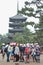 The teacher lead the young students wearing hats for field trip while walking  and stand within Toji temple