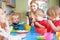 Teacher With Pre School Children Eating Healthy Snacks At Breakt