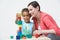 Teacher And Pre-School Pupil Playing With Wooden Blocks