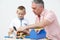 Teacher And Pre School Pupil Playing With Wooden Tools