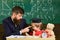 Teacher and pupil in mortarboard, chalkboard on background. Kid cheerful distracting while studying, attention deficit