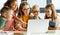 Teacher and pupils using laptop at school