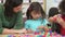 Teacher And Pupils Using Plastic Model Toys In Class