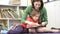 Teacher Reading Book With Female Pupil