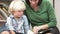 Teacher Reading Book With Male Pupil