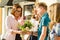 Teacher`s Day, outdoor portrait of happy middle aged female high school teacher with bouquet of flowers and group students.