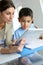 Teacher and schoolboy using tablet in class