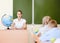 Teacher and schoolchildren in classroom at lesson