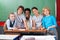 Teacher With Schoolchildren At Desk In Classroom