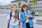 Teacher and schoolgirl child looking at camera outdoor, school building background